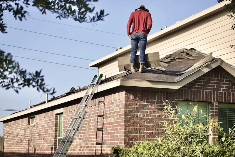 Professional roofer working on a residential roof in Slate Valley